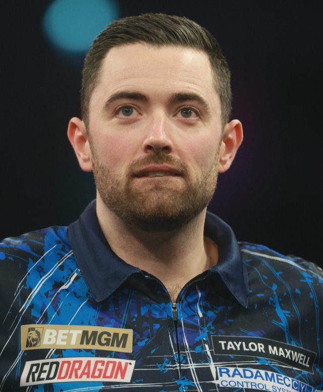 Darts players compete on stage at Alexandra Palace as a 180 score lights up the board during the PDC World Darts Championship.