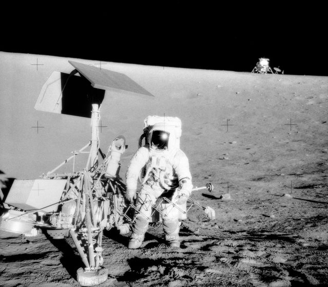 A grainy 1969 NASA lunar surface photo with two bright spots circled near the horizon, released by the Pentagon as unexplained Apollo 12 phenomena.