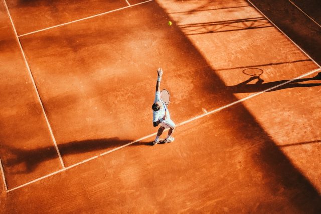 Carlos Alcaraz celebrates with the French Open trophy on the clay court at Stade Roland Garros after winning the 2024 final.