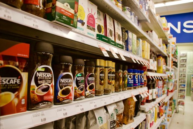 Prepackaged sandwiches and salads on a supermarket shelf, with a sign indicating a recall due to E. coli contamination