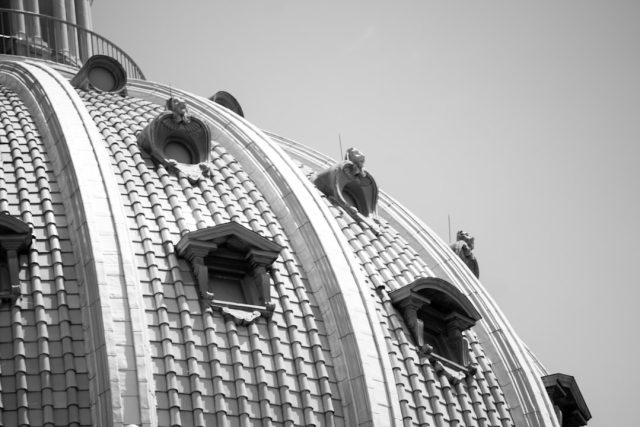 Grainy black and white photo with a crosshair reticle centered on a bright circular object against a smooth background.