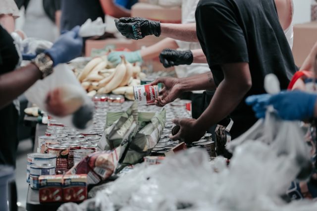 Emergency workers stand amid debris of a collapsed church roof in Recife, Brazil, with food distribution supplies scattered nearby.