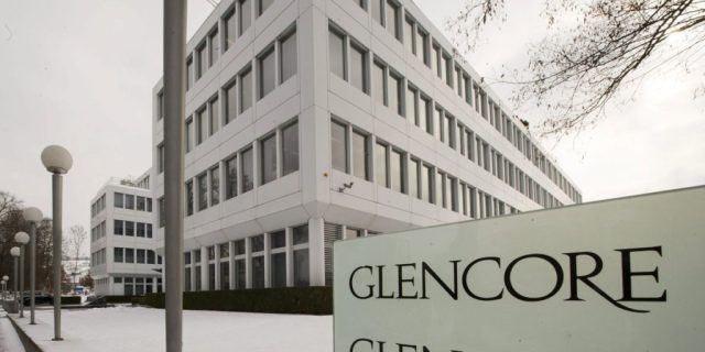 Glencore logo on a zinc smelter backdrop symbolizing its 60% grip on global zinc trade.