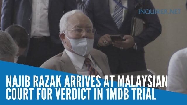 Stacks of seized cash and luxury items displayed on tables as evidence in the 1MDB money-laundering probe.