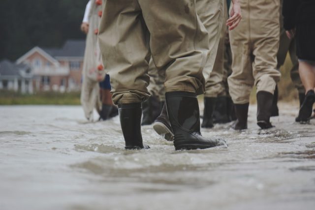 Rescue workers search through debris and muddy floodwaters in a low-lying area of Nepal after flash floods destroyed homes.