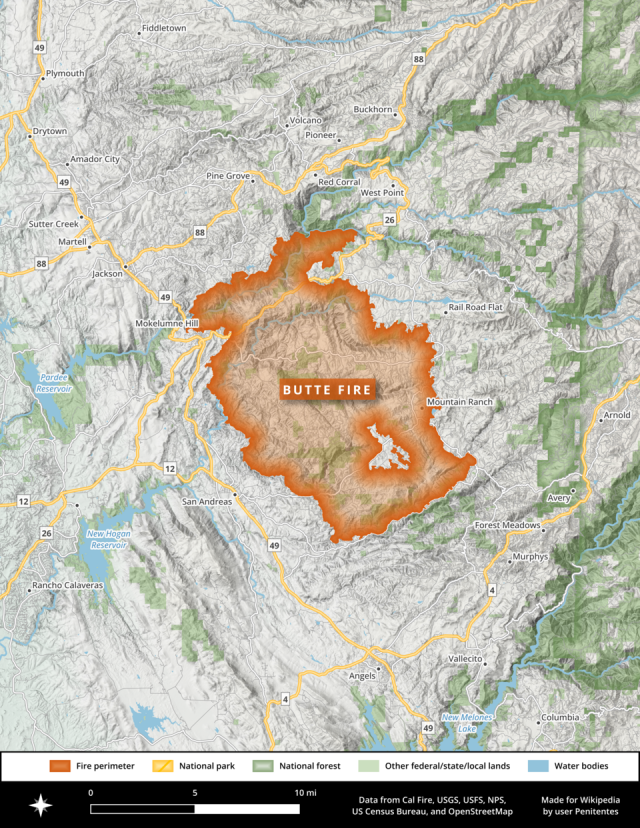 Aerial view of the Park Fire raging through forested hills in Northern California, with smoke billowing over the landscape.