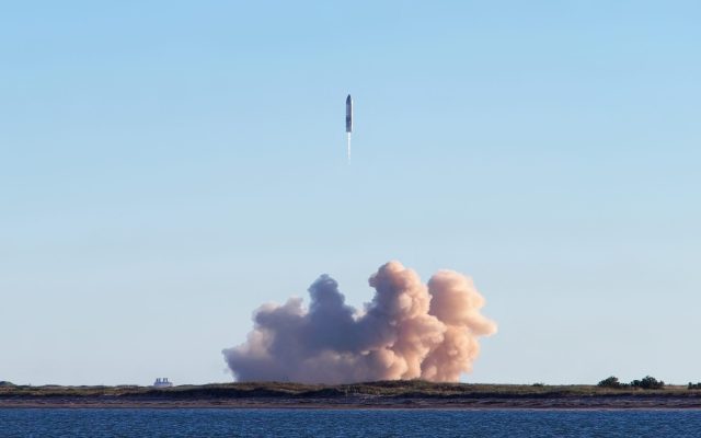 SpaceX Starship launches from Texas site at dusk with bright exhaust plume against sky