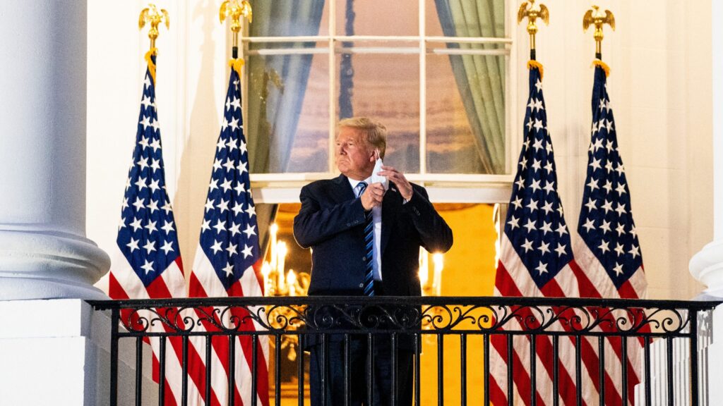 President Trump stands at the White House lectern on August 19, 2020, urging mask use as officials look on.